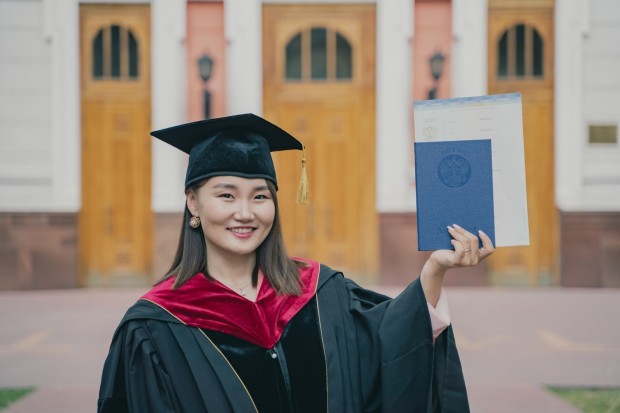 a woman in a graduation cap and gown holding a diploma