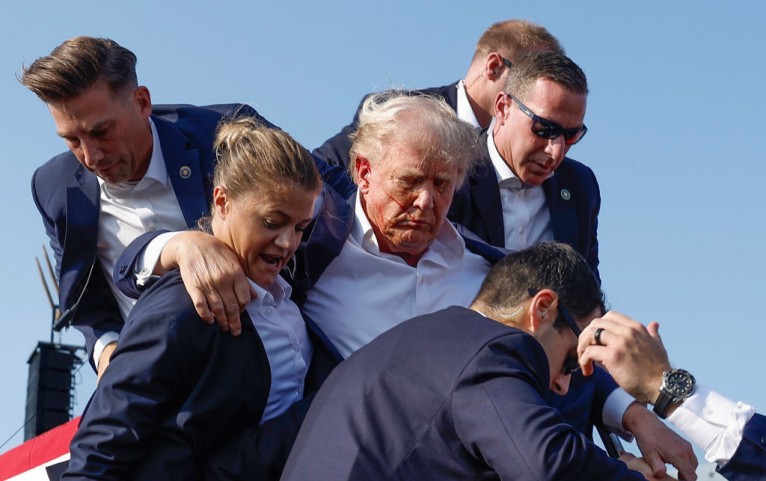 Republican presidential candidate former President Donald Trump is rushed offstage by U.S. Secret Service agents after being grazed by a bullet during a rally on July 13, 2024 in Butler, Pennsylvania. 